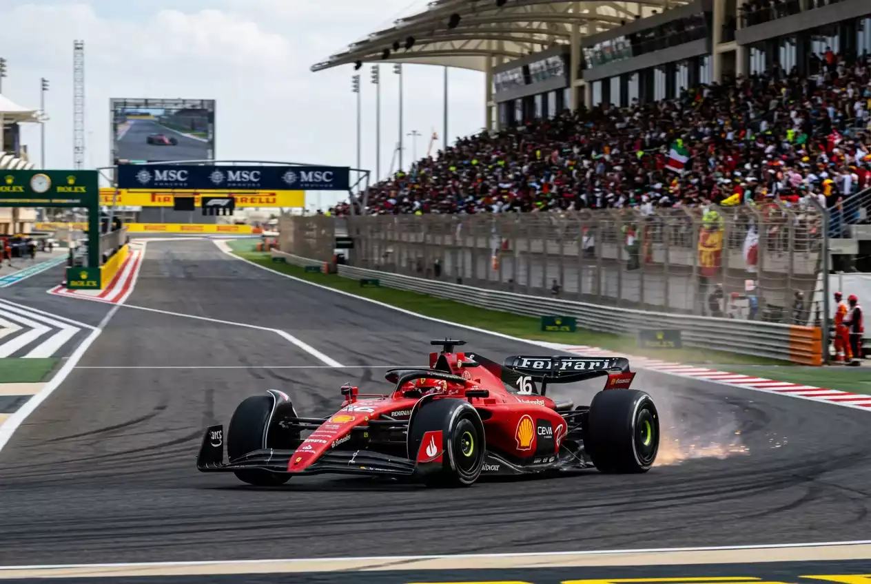 Monoplaza rojo de Fórmula 1 en la recta principal de un circuito con gradas al fondo